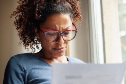 Portrait of worried woman standing beside window