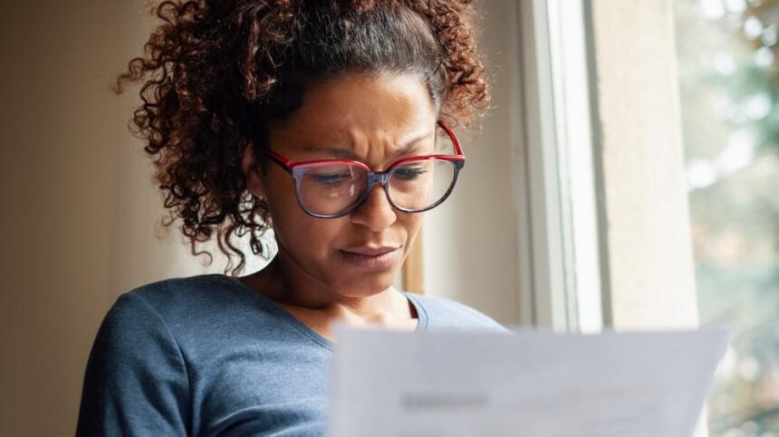 Portrait of worried woman standing beside window