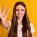 Young Caucasian woman holding up four fingers