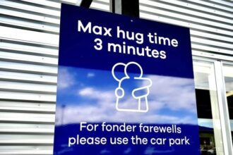 A sign informing time limits for visitors to the passenger drop-off area outside Dunedin Airport in Momona, New Zealand, Oct. 8, 2024. Travelers wanting to embrace for longer can relocate to the parking lot. (Sarah Soper/Dunedin Airport via AP)