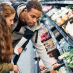 Girl buying groceries in the supermarket with her father.