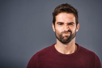 Young Caucasian man making doubtful face at camera