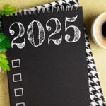 New year resolutions 2025 on desk. 2025 resolutions list with notebook, coffee cup on table.